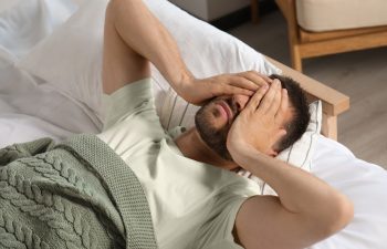 Sleepless man lying in bed at home