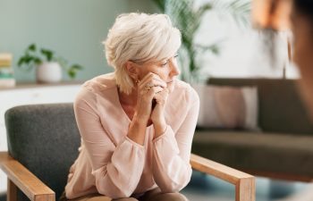 Depression, psychology or old woman thinking with psychologist in consultation office for mind, evaluation or assessment. Help, stress or sad client with therapist for counseling, help or ptsd trauma